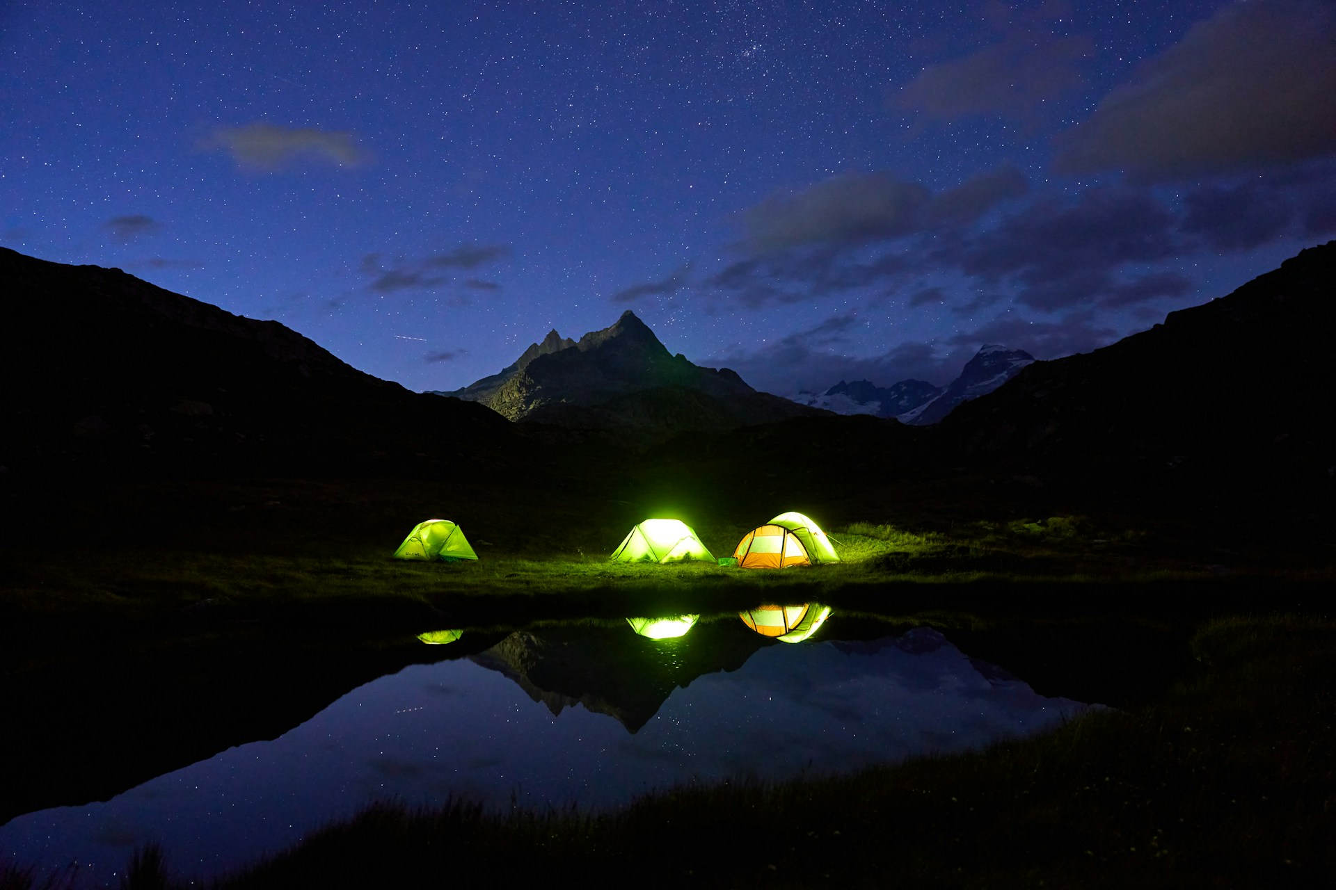 a couple of tents sitting on top of a lush green field