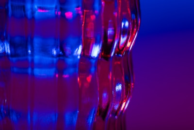 Abstract shot of vibrant blue and orange lighting reflecting on glass surfaces.