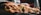 a close-up of several sandwiches lined up on a marble countertop. Each sandwich is filled with various ingredients such as meats, vegetables, and sauces. In the background, there are indistinct kitchen elements, and the image appears to be taken in a restaurant or deli setting.