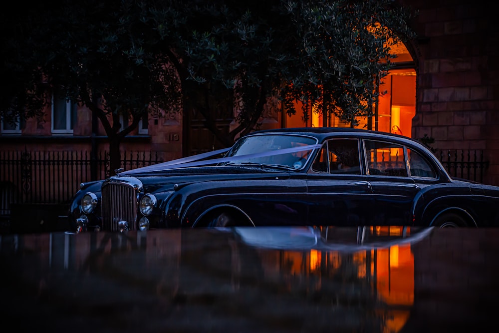 a classic car parked in front of a building