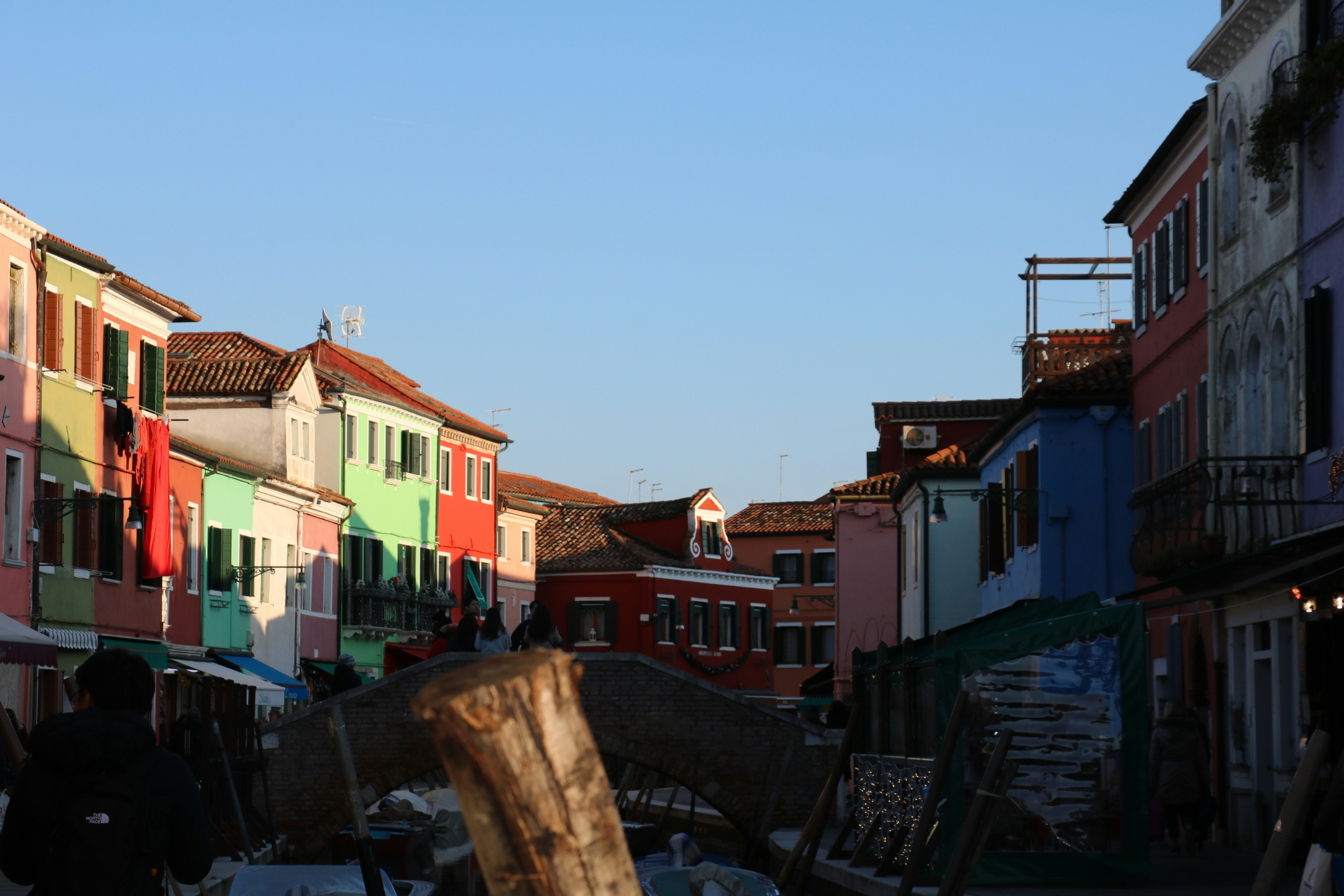 a group of people walking down a street next to tall buildings