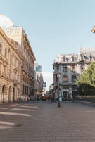 Historic cobblestone streets of Prague lined with colorful buildings under a clear blue sky.