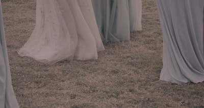A display of beautiful flowy dresses in a floral garden.