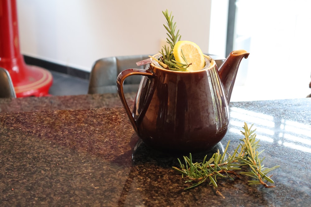 a tea pot with a lemon slice in it