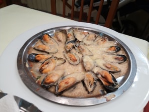 An elegant plate of mussels paired with a sun-kissed sauce.
