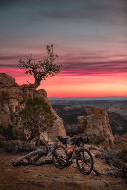 A scenic view of Monte Verde mountains with a quadricycle parked on a trail at sunset.