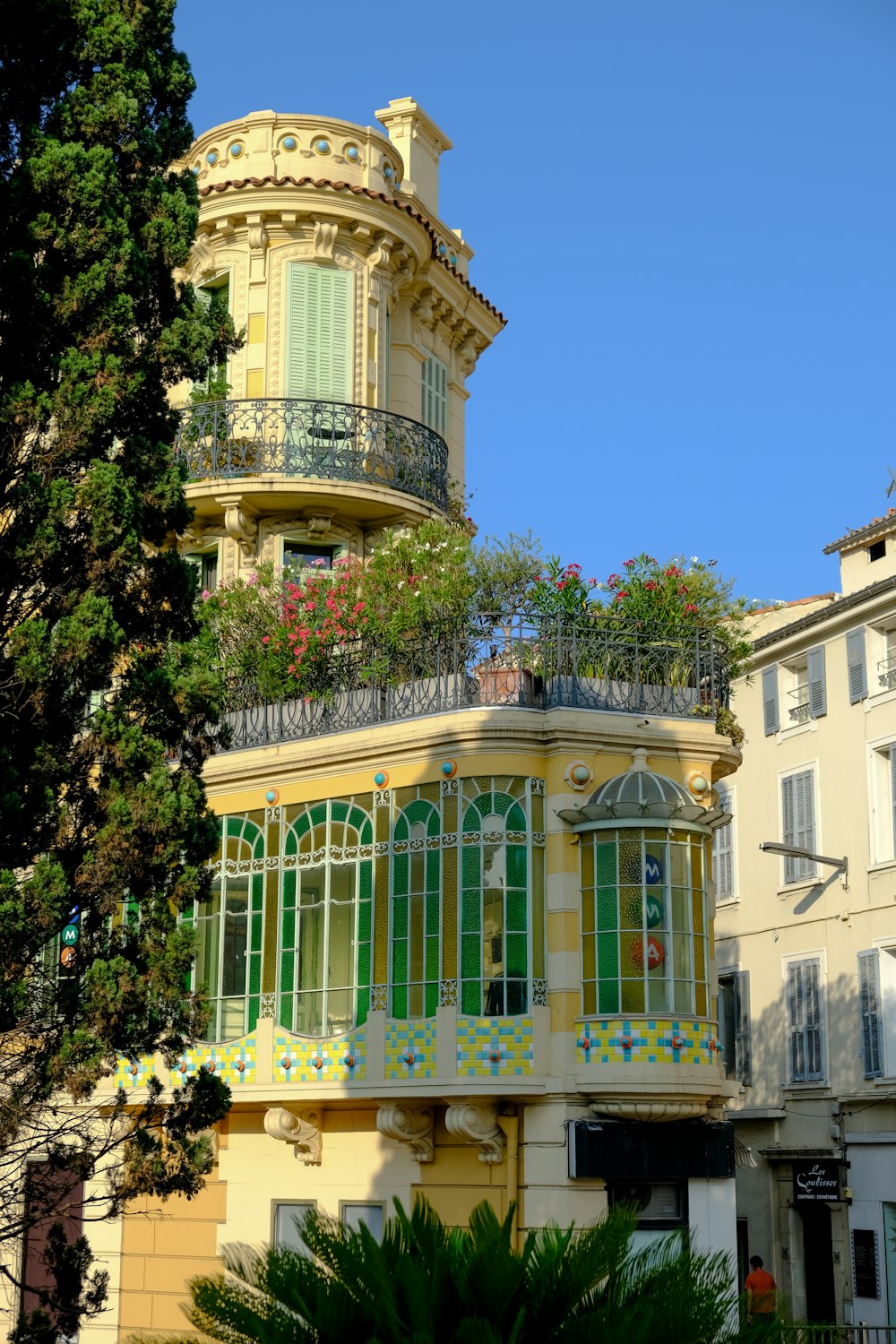 a yellow building with green windows and balconies