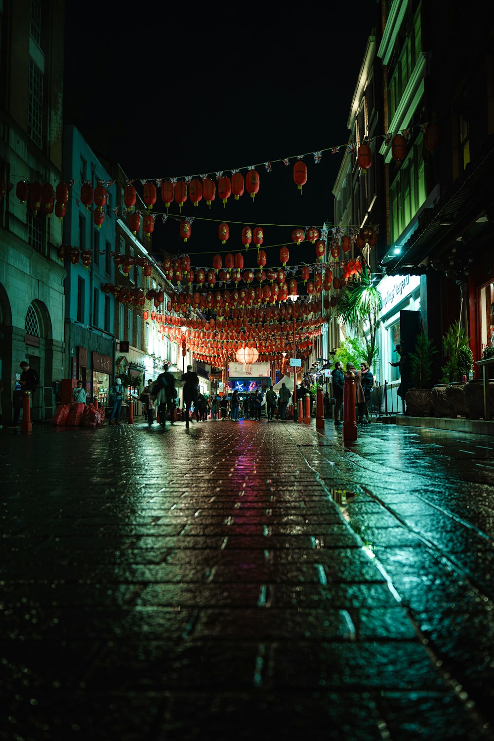 a city street at night with lanterns strung over it