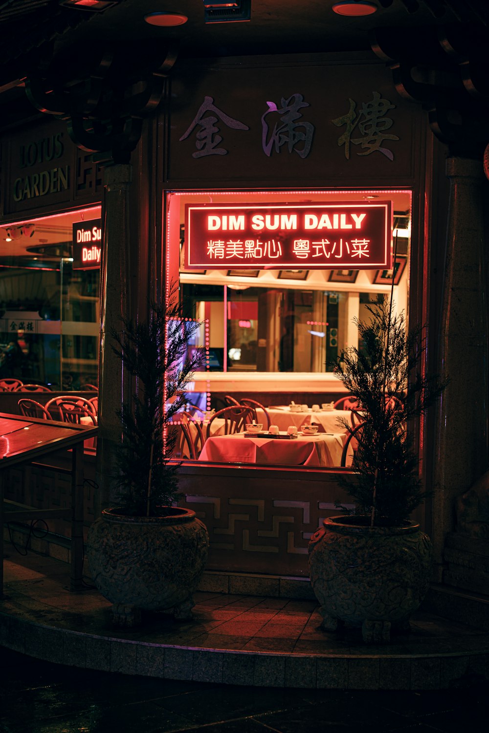 a restaurant with a red neon sign in front of it