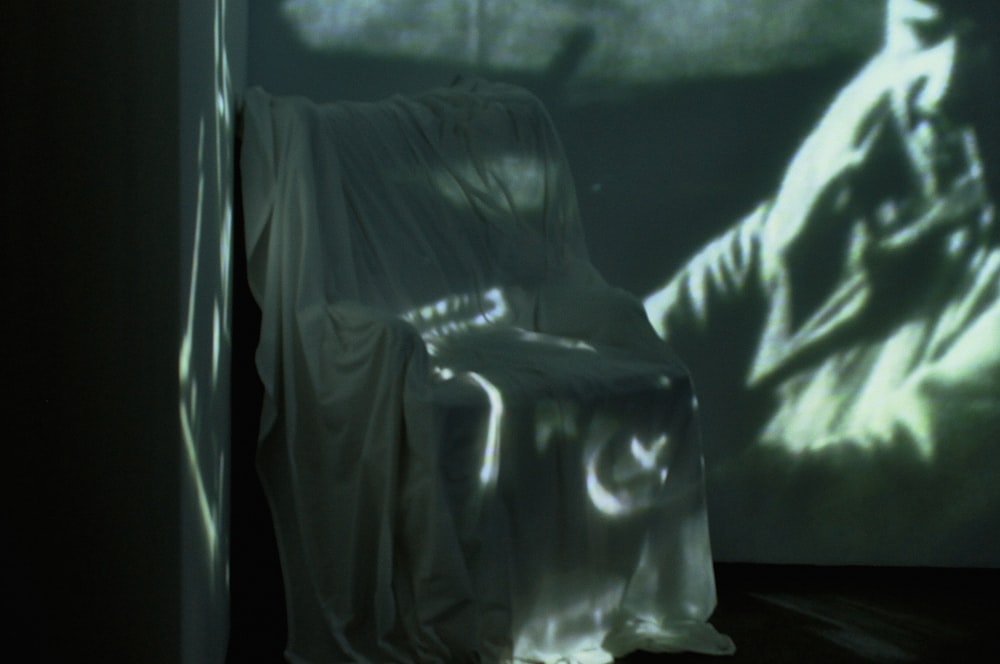 a chair sitting in front of a projection of a man
