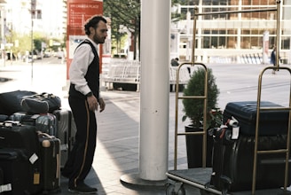 a man standing next to a pile of luggage
