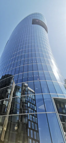 Sleek modern skyscraper with reflective glass facade under a clear sky.