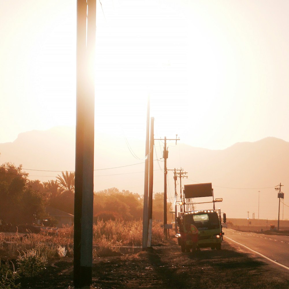 a truck driving down a road next to telephone poles