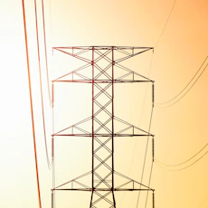 a high voltage power line against an orange sky