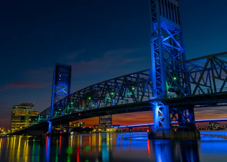 Nighttime shot of a steel bridge illuminated by subtle energy-green accent lighting, symbolizing innovation and resilience.