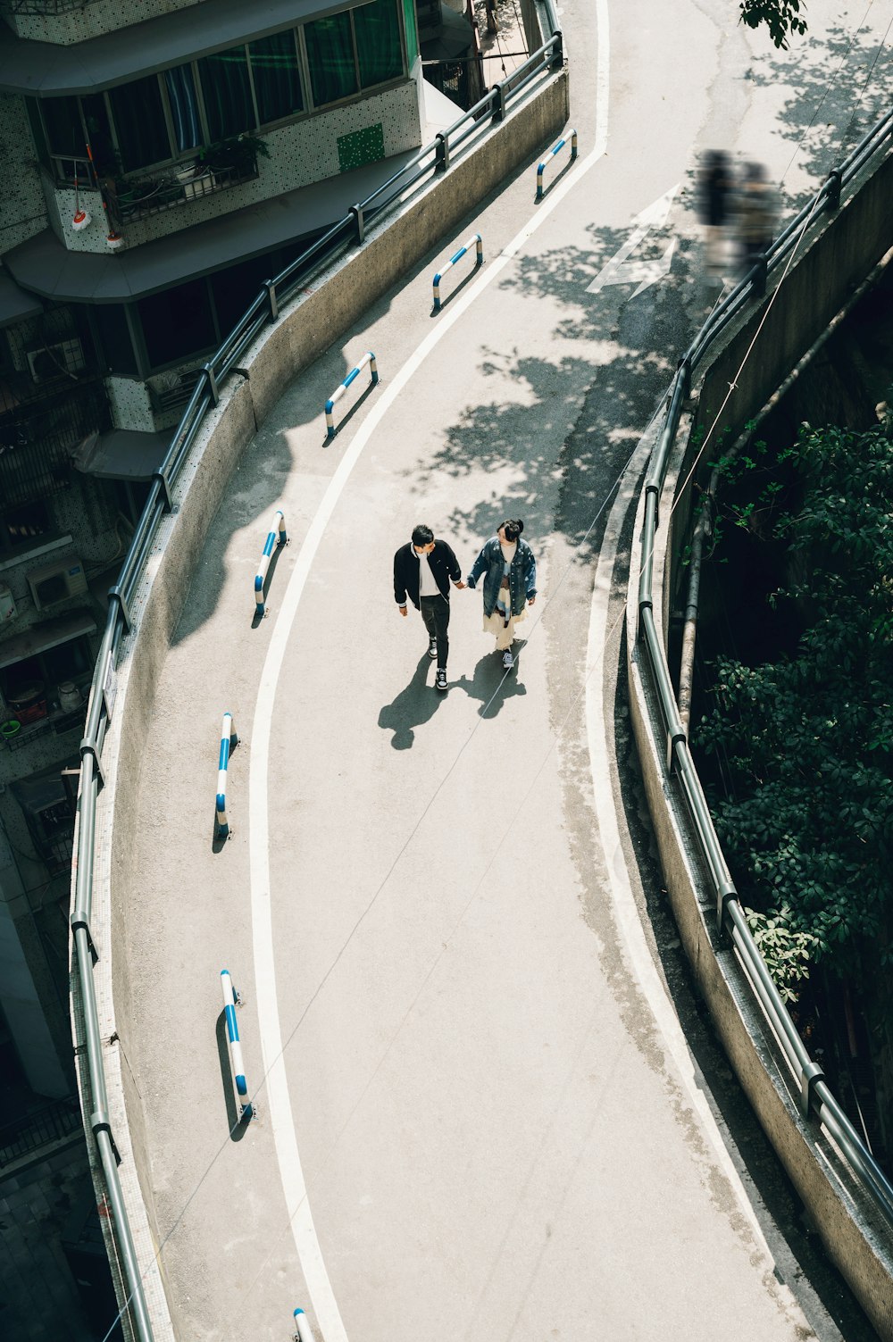 a group of people walking down a street next to a tall building