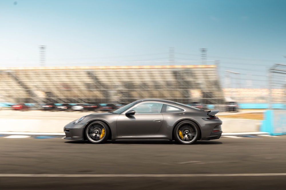 a grey car driving down a race track