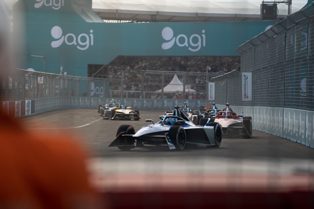 a group of racing cars driving down a race track