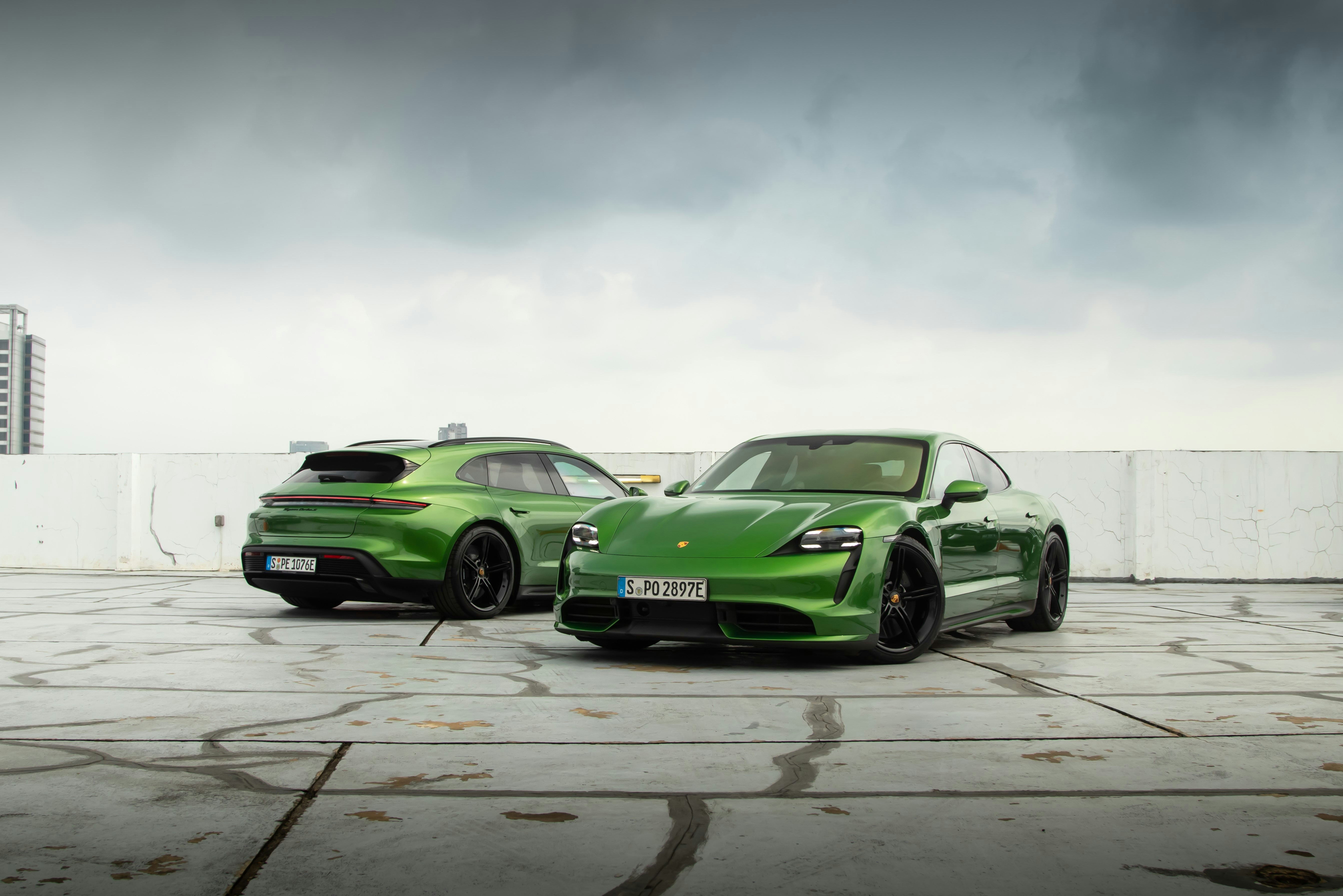 two green sports cars parked side by side