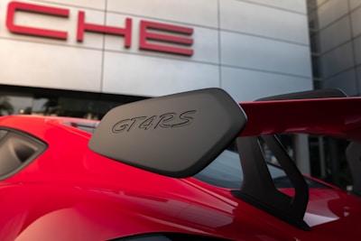 Close-up of the Porsche 911 GT3's red exterior with white and red outlined 'autos' text overlay.