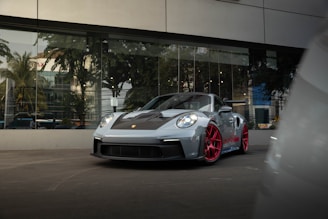 a grey sports car parked in front of a building