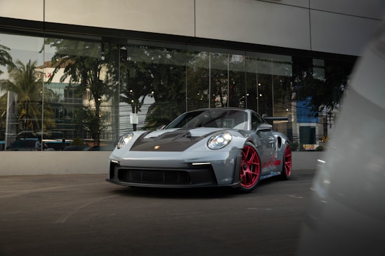a grey sports car parked in front of a building
