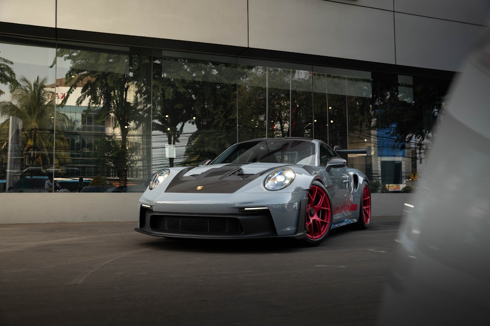 a grey sports car parked in front of a building