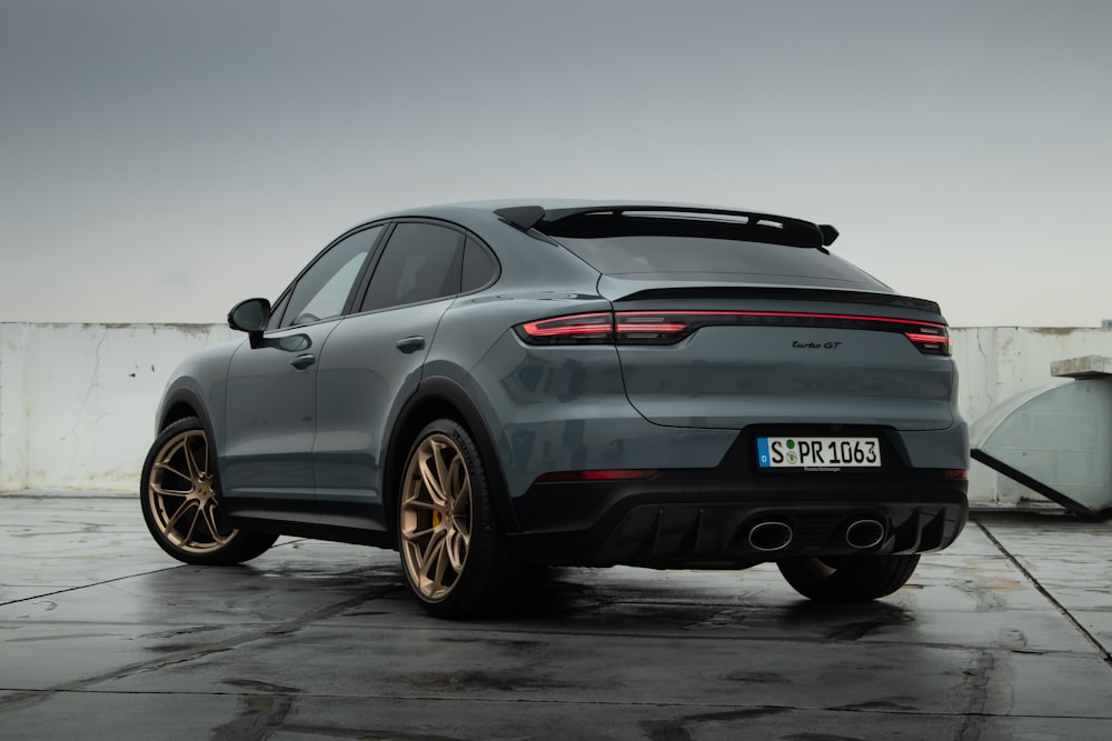 a grey porsche cayen is parked in a parking lot