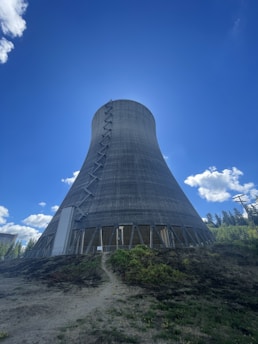 A close-up of a nuclear power plant cooling tower against a clear blue sky.