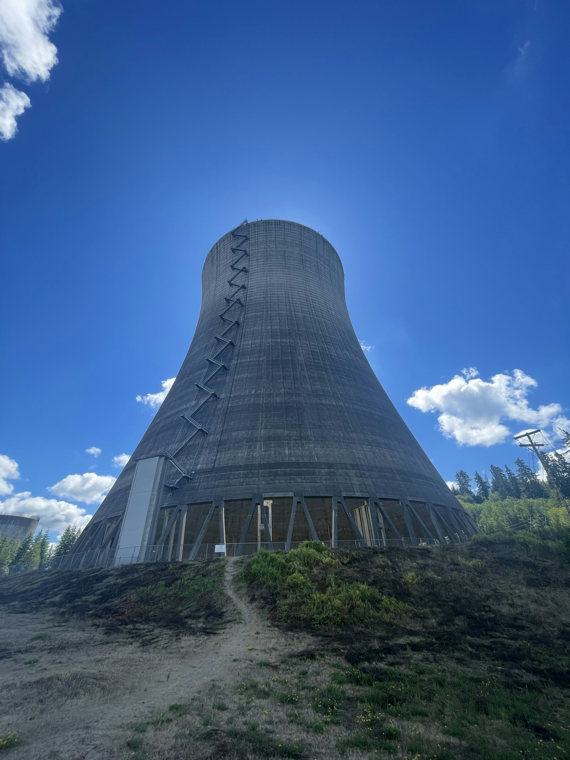 A stunning image of a modern cooling tower surrounded by a clear blue sky.