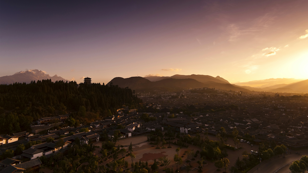 an aerial view of a city with mountains in the background