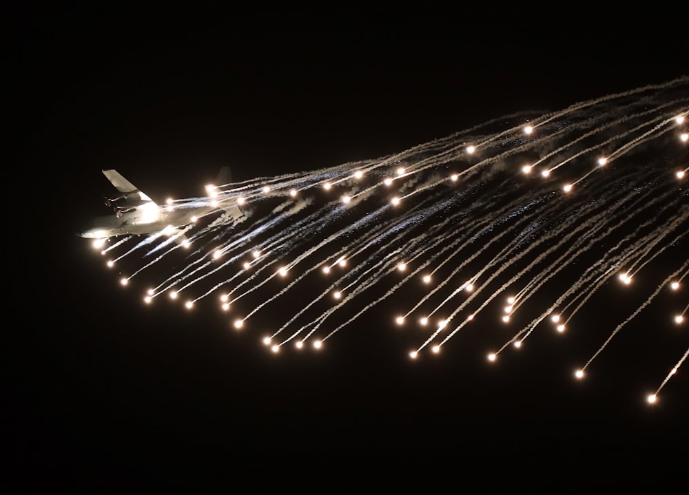 a large jetliner flying through a sky filled with lots of lights