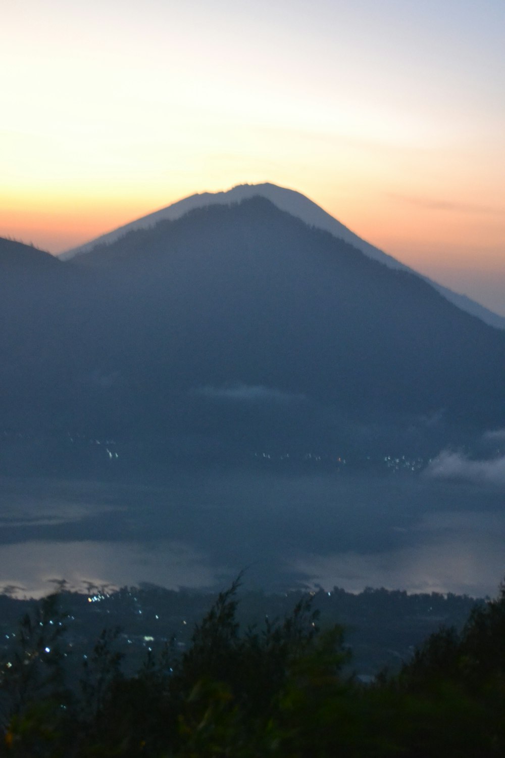 a view of a mountain with fog in the air