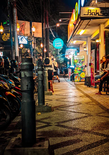 A lively night scene in Ho Chi Minh City with people enjoying dining and nightlife.