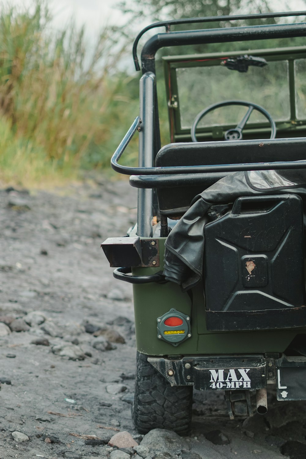 a green jeep parked on top of a rocky road