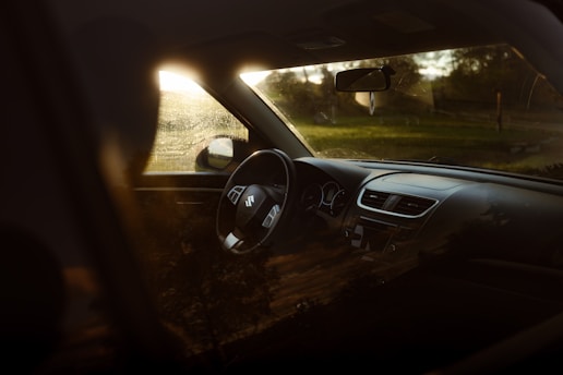 A close-up of a shiny car dashboard with sunlight streaming through the windshield.