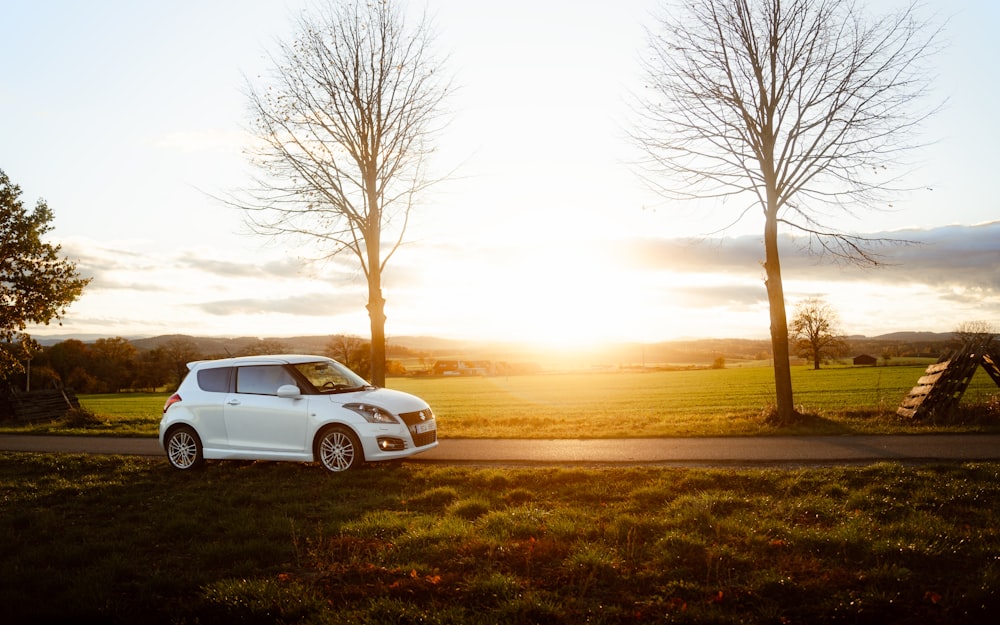 a small white car parked on the side of a road