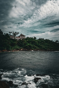 a house sitting on top of a lush green hillside