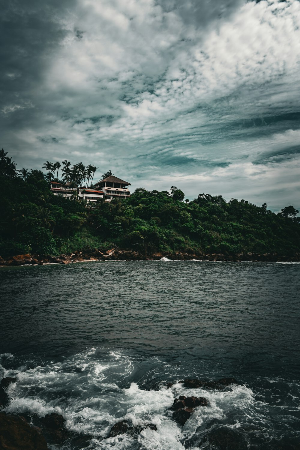 a house sitting on top of a lush green hillside