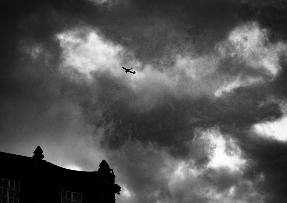 a black and white photo of a plane in the sky