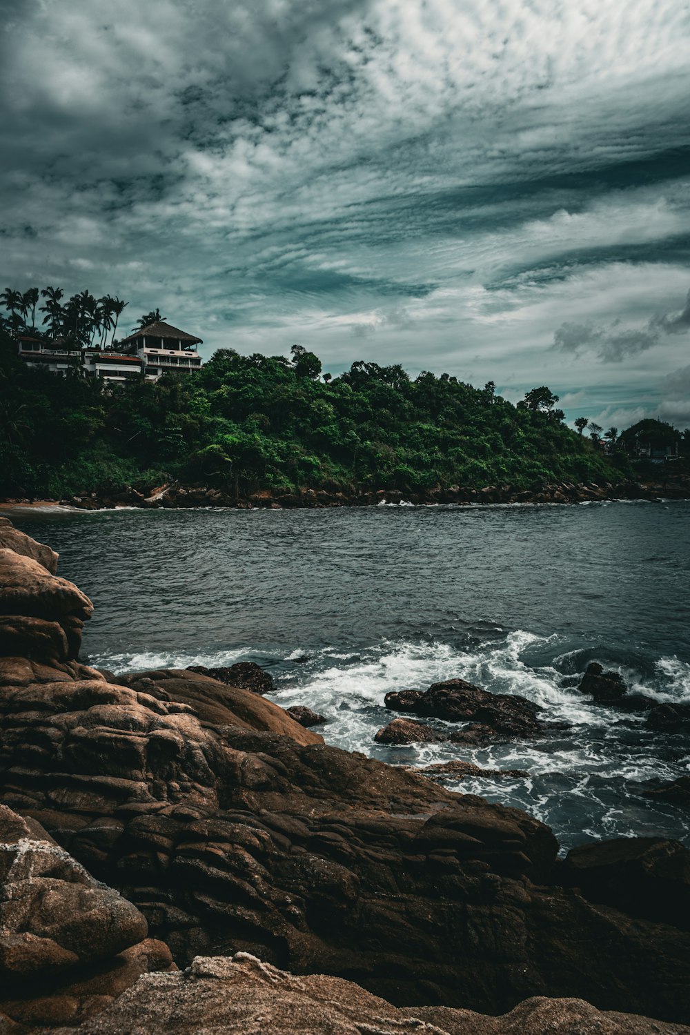 a large body of water sitting next to a lush green hillside