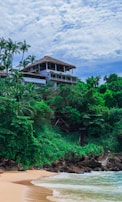 a beach with a house on top of a hill