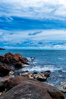 a large body of water sitting next to a rocky shore