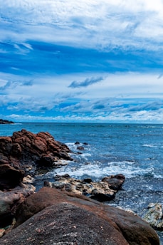 a large body of water sitting next to a rocky shore