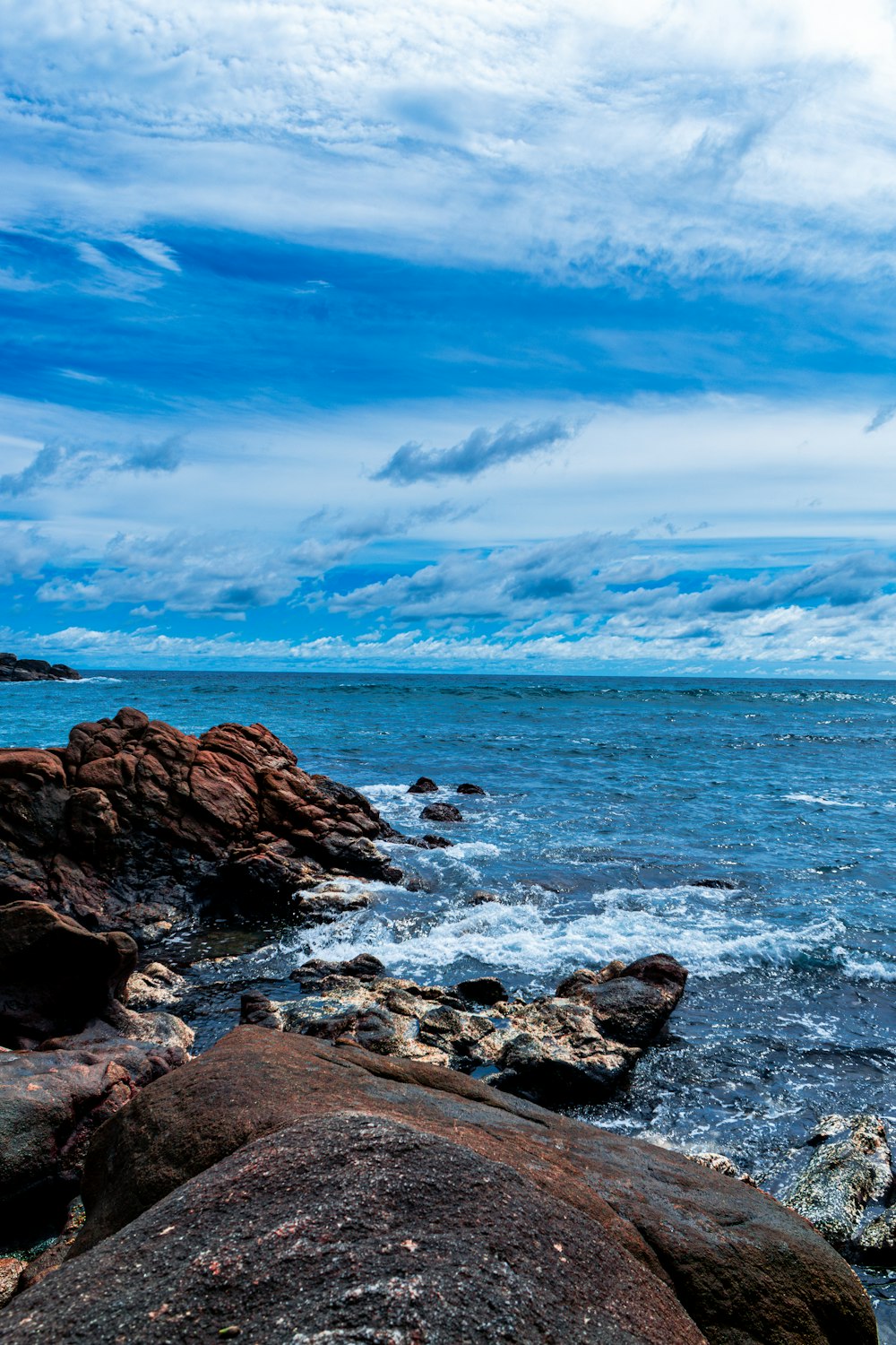 a large body of water sitting next to a rocky shore