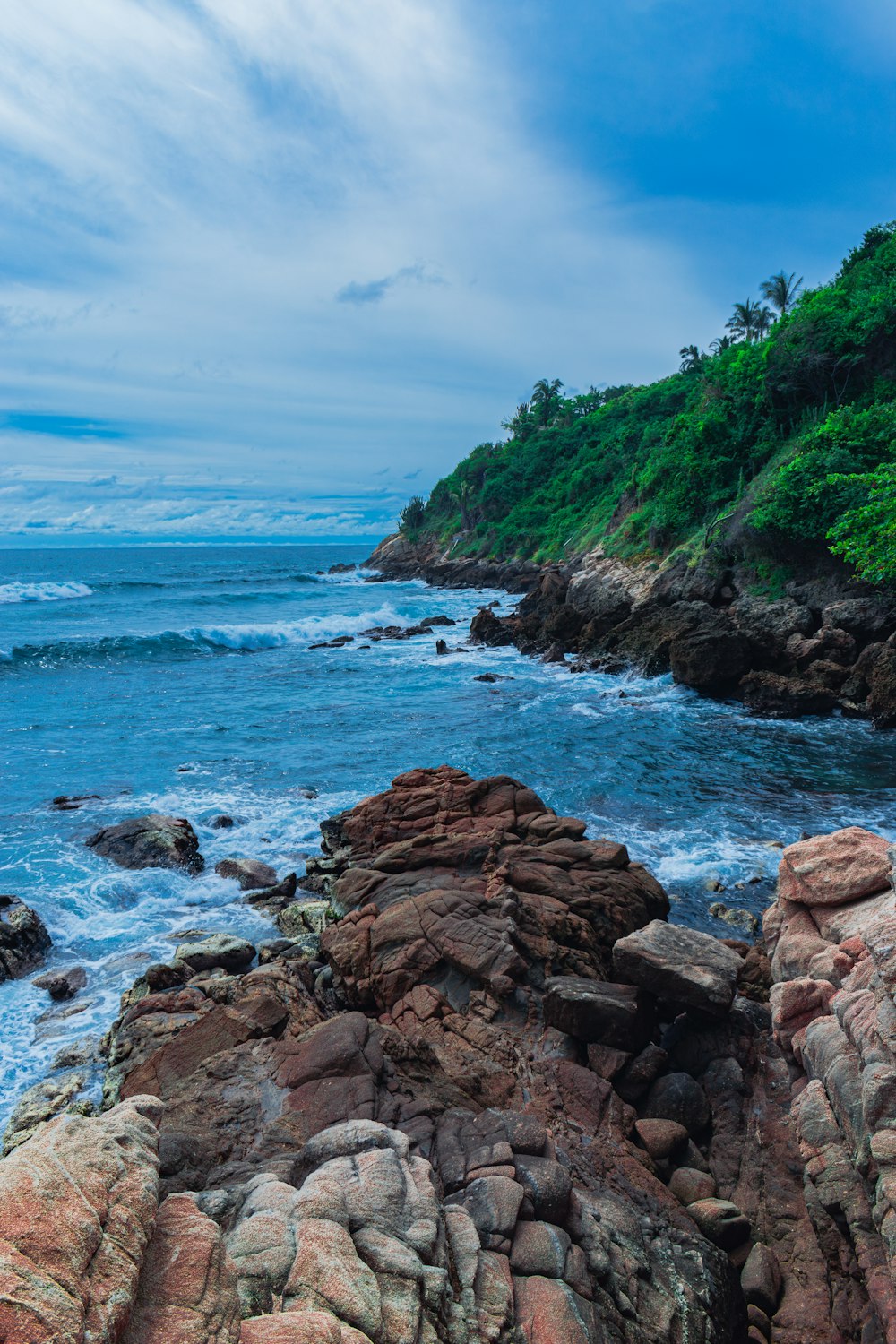 a view of the ocean from a rocky shore