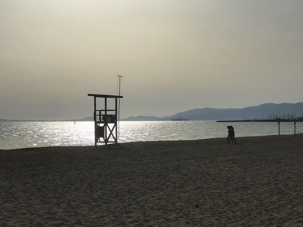 Un homme debout au sommet d’une plage de sable à côté de l’océan