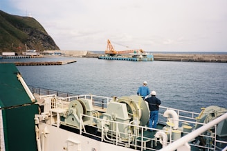 a couple of men standing on top of a boat