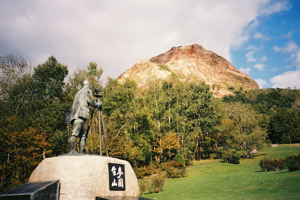 a statue of a man on a horse with a mountain in the background