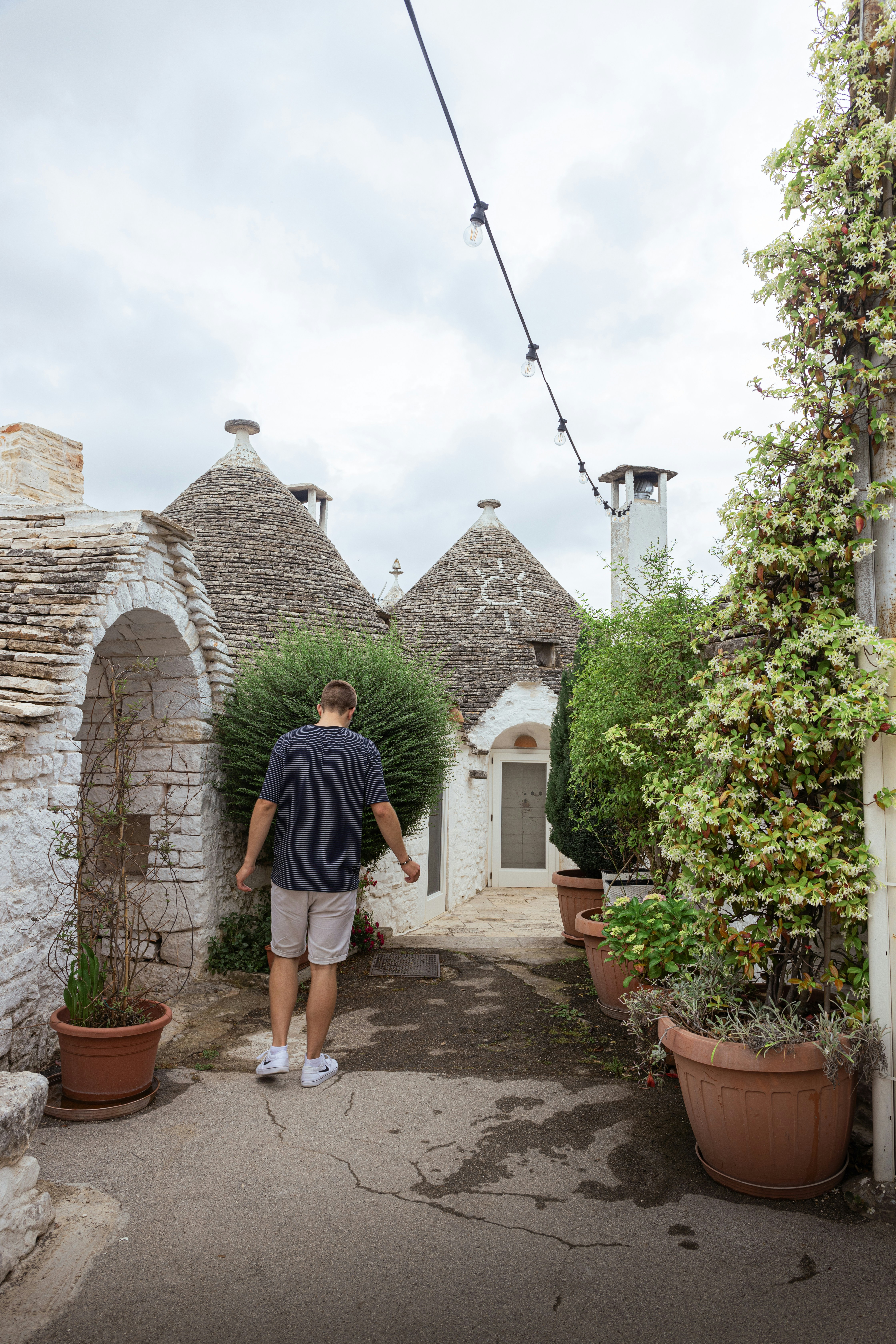 A man walking down a path between two buildings photo – Free Portrait ...